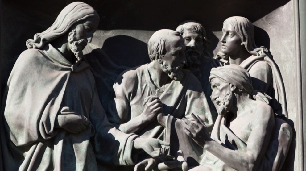 A detailed relief sculpture depicting Jesus healing a group of people, symbolizing divine mercy and compassion.