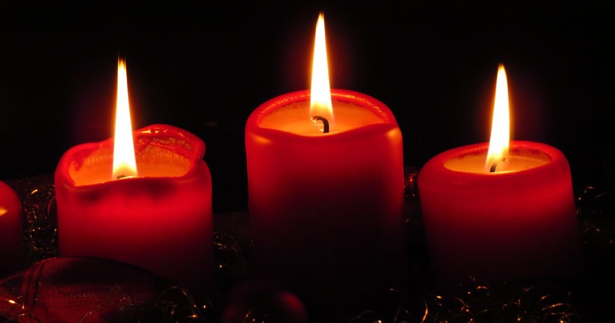 Three glowing red candles symbolizing peace and reflection, representing the essence of pastoral care and spiritual guidance.